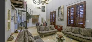 una sala de estar con sofás y una lámpara de araña. en Luxury Large Apartment With Colonial Balcony, en Cartagena de Indias