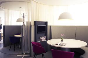 a room with a table, chairs and a lamp at Mercure Hotel Nijmegen Centre in Nijmegen