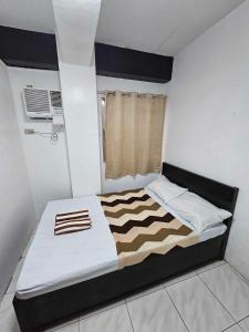 a bedroom with a bed with a black and white comforter at Villa Tomasa Boracay Dmall in Boracay