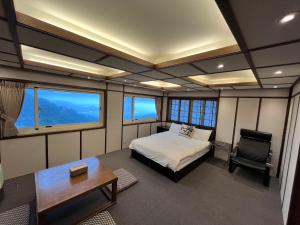 a room with a bed and a desk and a chair at Shanhai Guan B&B in Ruifang