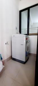 um frigorífico branco num quarto com uma janela em Căn hộ 53m đủ nội thất 1PN 1WC bếp free hồ bơi, GYM, BBQ tại Warterpoint Bến Lức em Bến Lức
