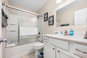 uma casa de banho com um chuveiro, um WC e um lavatório. em Niceville Dream Home Sleeps 13 em Niceville