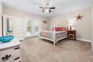 Niceville Dream Home Sleeps 13 في نايسفيل: غرفة نوم مع سرير أطفال وطاولة ومروحة سقف