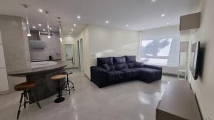 a living room with a couch and a kitchen at SARDINERO in Santander