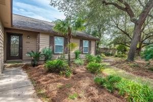 a house with a palm tree and a sidewalk at Niceville Dream Home Sleeps 13 in Niceville