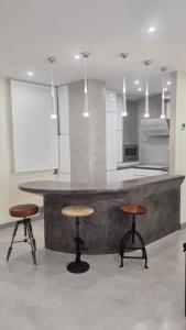 une cuisine avec un comptoir avec deux tabourets et une table dans l'établissement SARDINERO, à Santander
