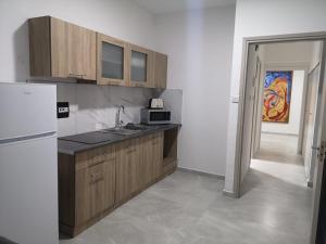 a kitchen with wooden cabinets and a refrigerator at Sun Hall Beach Hotel Apartments in Larnaka
