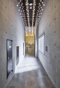 a hallway in a building with concrete walls and ceilings at Hotel Riverside Ulsan in Ulsan