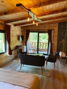 a living room with a couch and chairs in a cabin at Tepe Dağ Evleri in Çamlıhemşin