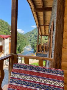 a room with a balcony with a view of a river at Tepe Dağ Evleri in Çamlıhemşin