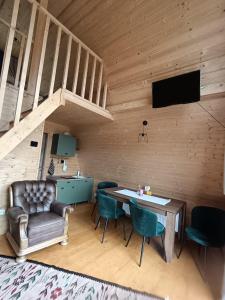 een woonkamer met een tafel en stoelen en een televisie bij CarpatinA Rustic House in Runcu