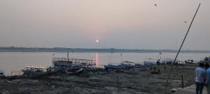 un grupo de barcos en la orilla de un cuerpo de agua en KRISHNA P. GUEST HOUSE en Varanasi