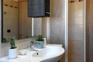 un bagno con lavandino con due piante sopra di KRIS87 A 5 Minuti dal Porto ad Alghero
