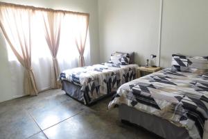 1 Schlafzimmer mit 2 Betten und einem Fenster in der Unterkunft Faith City Guesthouse in Outjo