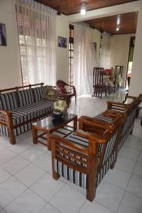 a living room with couches and a table and chairs at Villa Roma - Negombo in Negombo