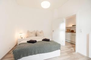 een witte slaapkamer met een bed met twee handdoeken erop bij Exklusive Wohnung am Weserdeich in Bremen