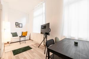 ein weißes Wohnzimmer mit einem Tisch und einem TV in der Unterkunft Exklusive Wohnung am Weserdeich in Bremen