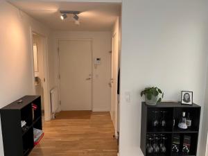 a hallway with a white door and a black shelf at Charming Aalborg Apartment With parking in Aalborg