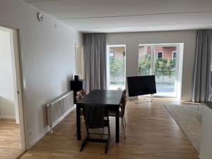 a dining room with a table and a television at Charming Aalborg Apartment With parking in Aalborg