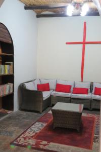 ein Wohnzimmer mit einem Sofa und einem Kreuz an der Wand in der Unterkunft Faith City Guesthouse in Outjo