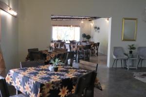 a dining room with tables and chairs with flowers on them at Faith City Guesthouse in Outjo