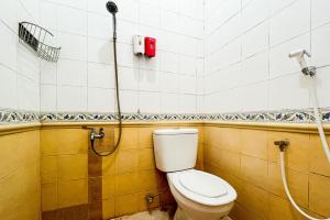 a bathroom with a toilet and a shower at RedDoorz Syariah At Santana Stasiun Kepanjen in Malang