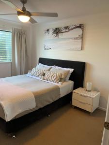 een slaapkamer met een bed en een plafondventilator bij Marcoola Beach Resort in Marcoola