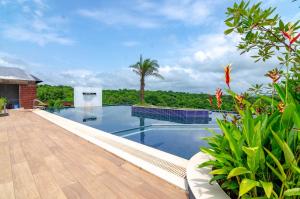 a swimming pool in a resort with a wooden deck at Dio Regaalo Theme Resort, Ratnagiri in Ratnagiri