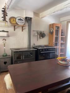 a kitchen with a stove and a wooden table at La bergerie in Roubion