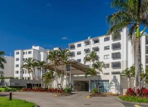 un grand bâtiment blanc avec des palmiers devant lui dans l'établissement Marcoola Beach Resort, à Marcoola