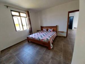 Schlafzimmer mit einem Bett und einem Fenster in der Unterkunft Villa Deux Bras 