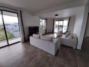 a large living room with two couches and a television at Villa Deux Bras in Deux Bras