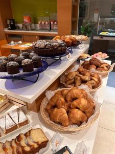 una panetteria con molti tipi diversi di dolci e torte di The Bergamo West Motel a Mozzo