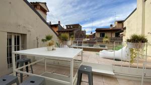 un patio avec une table et des chaises blanches sur un balcon dans l'établissement Loft 17 Arena, à Vérone