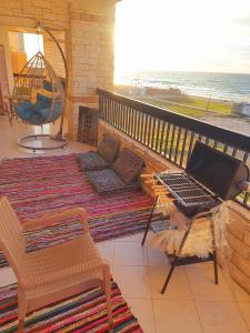 un balcon avec un ordinateur portable assis sur une table dans l'établissement Hotel appartment sea view 3 bedrooms 3 toilets 4th floor Bellevue village agami alexandria families are preferred available all year days & 5 blankets available, à Alexandrie