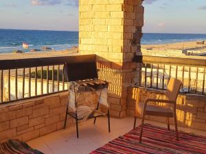 a grill on a balcony with a view of the beach at Hotel appartment sea view 3 bedrooms 3 toilets 4th floor Bellevue village agami alexandria families are preferred available all year days & 5 blankets available in Alexandria