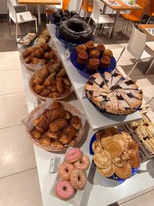 une table remplie de différents types de pâtisseries et de tartes dans l'établissement The Bergamo West Motel, à Mozzo