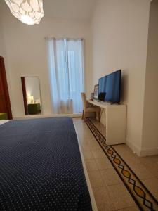 a living room with a tv and a desk with a computer at AcB Vaticano Suites in Rome