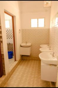 een badkamer met drie wastafels en drie wastafels. bij sevens residency in Sultan Bathery