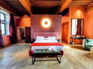 a bedroom with a large bed with orange walls at Les Chambres De La Renaissance in Sainte-Julie