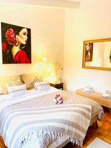 a bedroom with a large bed and a painting of a woman at Casa Calina in Mauguio