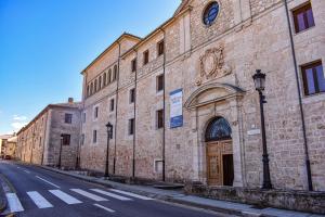 a large brick building with a door on a street at La Casona de 1717 in El Burgo de Osma