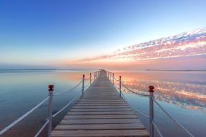 a dock stretches out into the water at sunset at Pickalbatros Royal Moderna Sharm "Aqua Park"- All inclusive in Sharm El Sheikh