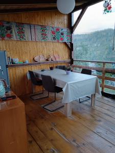 een tafel en stoelen in een kamer met uitzicht bij CarpatinA Rustic House in Runcu