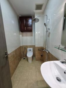 y baño con aseo blanco y lavamanos. en Linh's Home 101 Phòng riêng tiện nghi, en Tân Ðiền