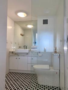 Baño blanco con aseo y lavamanos en Resort Queen Studio at Alex Beach Resort, en Alexandra Headland