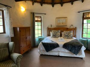 a bedroom with a bed and a chair and windows at Bramleigh Farm in Nottingham Road