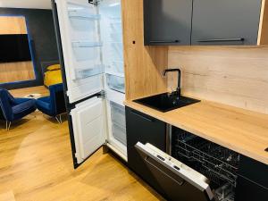 a small kitchen with a sink and a dishwasher at Apartmán Sitka in Trenčín