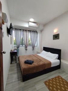 Suria Paradise Lodge في راناو: غرفة نوم بسرير كبير ونافذة