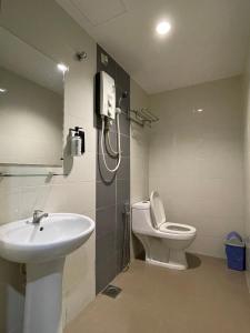 a bathroom with a sink and a toilet and a phone at M Three Hotel by SECOMS in Kampong Batu Tiga